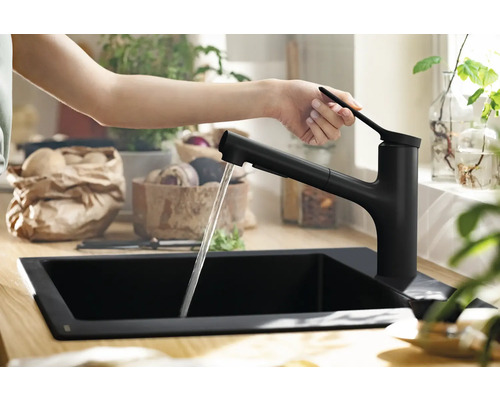 Schwarze Küchenarmatur mit fließendem Wasser in einem Spülbecken