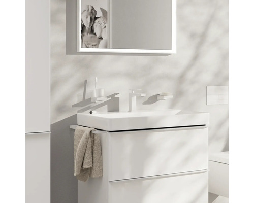 Modernes Badezimmer mit weißem Waschtisch, Spiegel und Handtuch