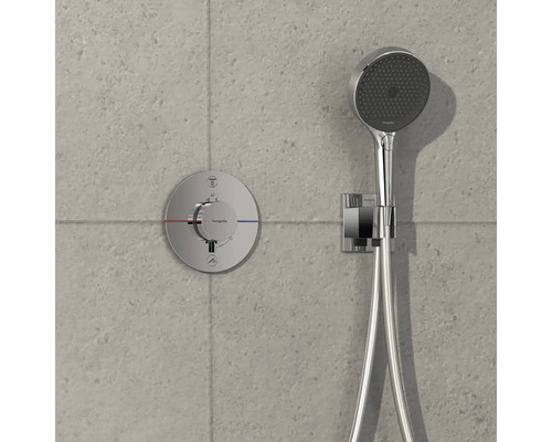 Aufputz-Brausebatterie mit Handbrause und Brauseschlauch vor grauer Wand