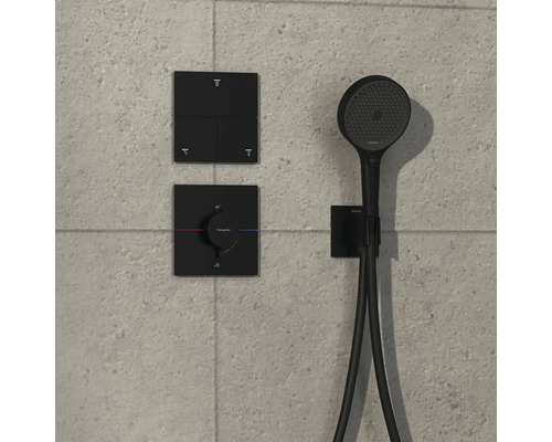 Schwarze Handbrausegarnitur mit Bedienelementen an der Wand