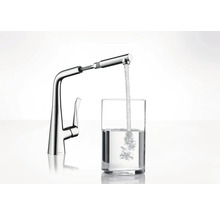 Küchenarmatur aus Metall mit Wasserhahn füllt ein Glas mit Wasser