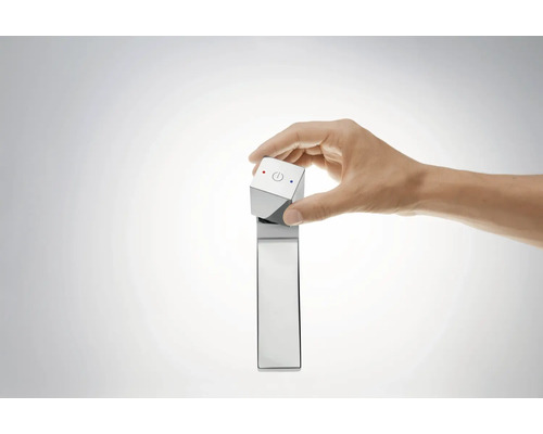 Eine Hand bedient einen Wasserhahn mit Temperaturregelung.