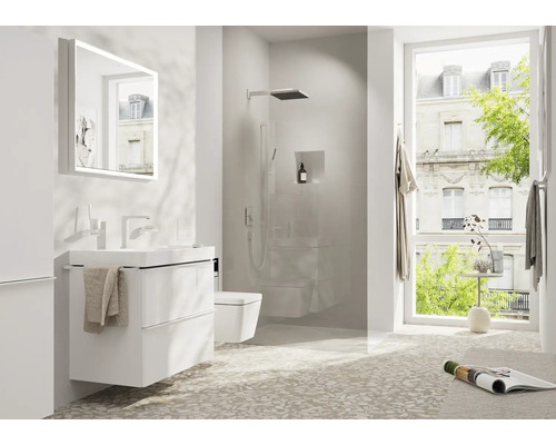 Helles Badezimmer mit Waschtisch, Spiegel, Dusche und Fenster.