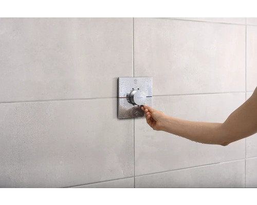 Hand betätigt Duscharmatur mit Temperaturregler an gefliester Wand