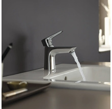 Wasserhahn aus Metall mit Wasserstrahl im Badezimmer