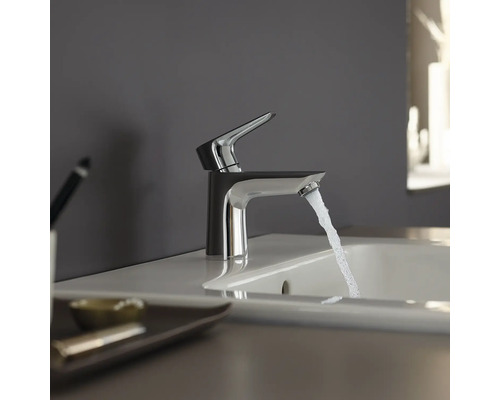 Wasserhahn aus Metall mit Wasserstrahl im Badezimmer