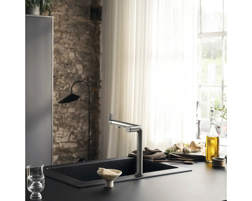 Küchenszene mit Spültischarmatur, Spüle, Geschirr und Küchenutensilien auf einer Arbeitsfläche