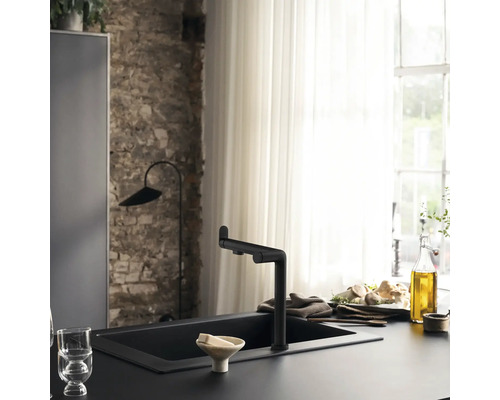 Küchenszene mit schwarzem Spülbecken und Armatur vor Backsteinwand