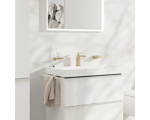 Modernes Badezimmer mit weißem Waschtisch, goldener Armatur, Spiegel und Accessoires