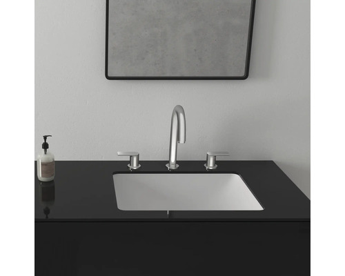 Waschbecken mit Armatur, Seifenspender und Spiegel im Badezimmer