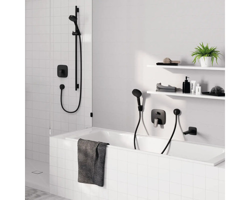 Badezimmer mit Badewanne, Duscharmatur und Ablageflächen