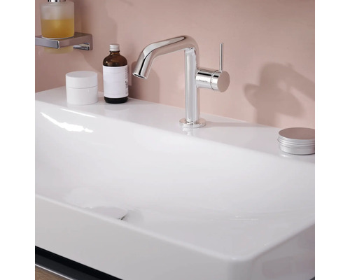 Auf einem Waschbecken befindet sich ein glänzender, silberfarbener Wasserhahn.