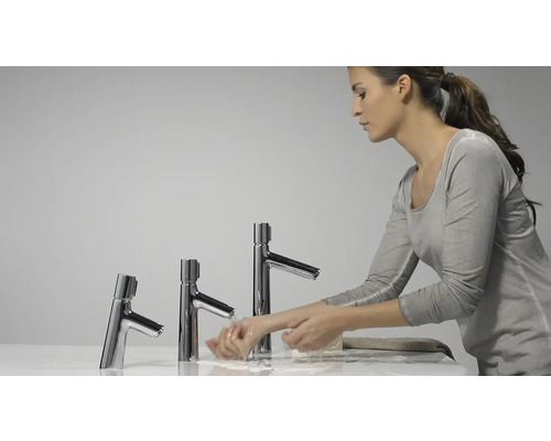 Frau wäscht sich die Hände an drei Chrom-Waschtischarmaturen