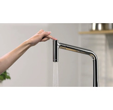 Wasserhahn mit Finger auf dem Knopf betätigt