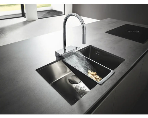 Spüle mit Abtropffläche, Wasserhahn und einigen Lebensmitteln, die auf der Arbeitsplatte liegen.