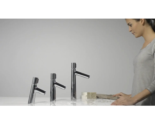 Drei Armaturen unterschiedlicher Höhe im Badezimmer mit einer Frau, die sich die Hände wäscht