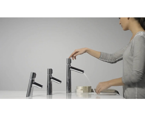 Frau bedient einen Wasserhahn in verschiedenen Größen im Badezimmer