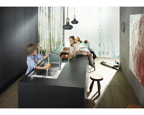 Moderne Küche mit Kindern an der Kücheninsel beim Äpfelwaschen