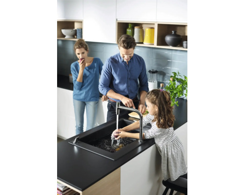 Familie in einer hellen Küche mit Spüle und Armatur beim Gemüsewaschen