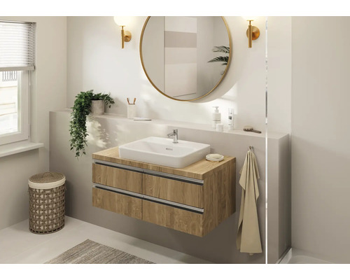 Helles Badezimmer mit Waschtischunterschrank, Spiegel und Dekorationen.
