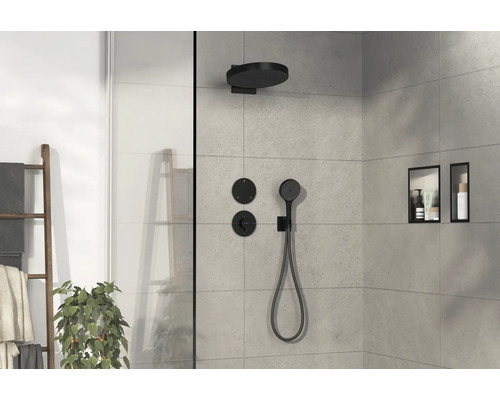 Helle Duschkabine mit schwarzer Armatur, Regendusche und Handbrause sowie Ablagenischen in der Wand