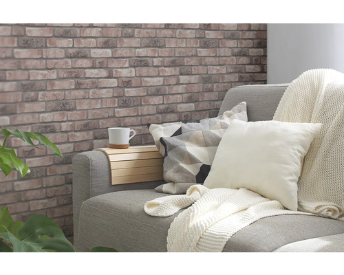Gemütliches Wohnzimmer mit Backsteinmuster-Tapete, Sofa, Kissen und Beistelltisch