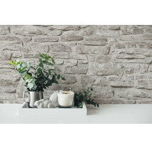 Dekorative Wand mit Steinoptik, Arrangement mit Kerze und Pflanze