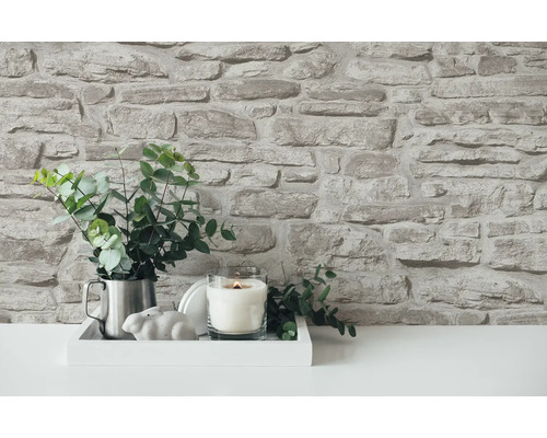 Dekorative Wand mit Steinoptik, Arrangement mit Kerze und Pflanze