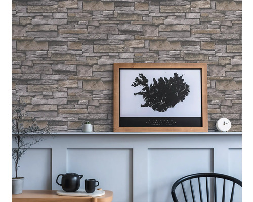Wohnraum mit einer Wand mit Steinoptik-Tapete und einem gerahmten Island-Poster