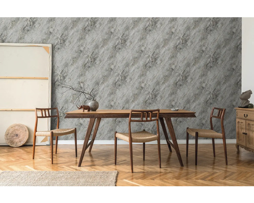 Esszimmer mit Holztisch, Stühlen und grauer Tapete mit Steineffekt.