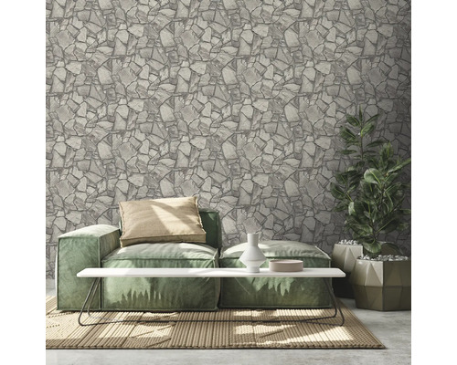 Wohnzimmer mit Steinoptik-Tapete, Sofa, Tisch und Pflanze
