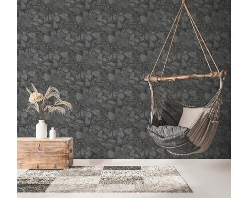 Wohnzimmer mit Steinmuster-Tapete, Hängekorbsessel, Truhe und Teppich