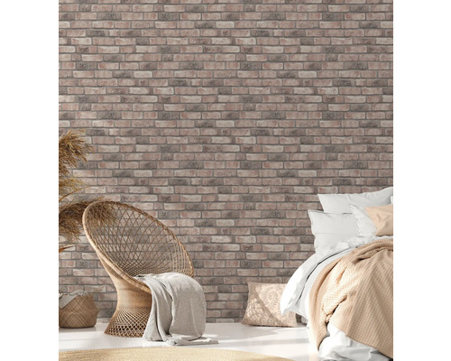 Helles Schlafzimmer mit Ziegelwandtapete, Rattansessel und Bett