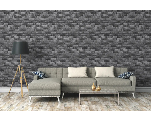 Wohnzimmer mit grauer Ziegelwandtapete, Sofa, Stehlampe und Couchtisch