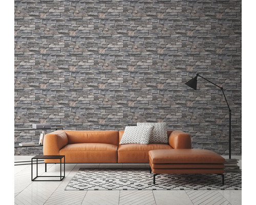 Wohnzimmer mit grauer Steinoptik Tapete, Couch und Lampe.