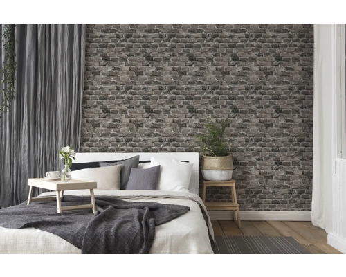 Schlafzimmer mit Bett, Nachttisch, Vorhängen und Tapete in Backsteinoptik für ein gemütliches Ambiente