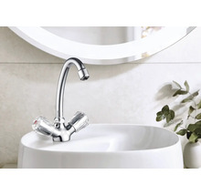 Glänzender Wasserhahn mit transparenten Griffen auf einem weißen Waschbecken