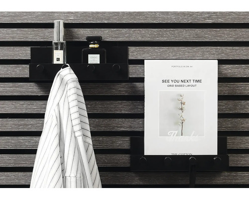 Schwarzes Wandregal mit Jacke, Parfüm und A4-Papier