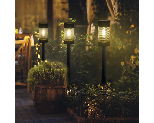 Drei Solarleuchten im Garten bei Nacht, die eine angenehme Atmosphäre schaffen.