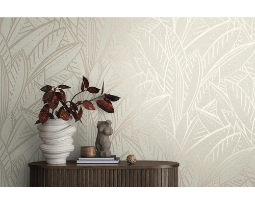 Dekoratives Zimmer mit Vliestapete mit Blattmuster, Pflanze und Tisch