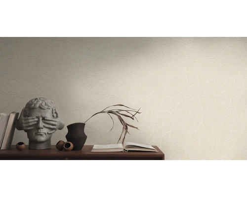 Wohnszene mit gemusterter Tapete, Bücherstapel und dekorativen Objekten auf einem Sideboard