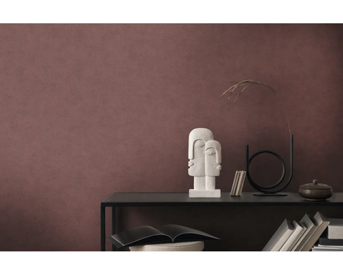 Dekoratives Arrangement auf einem schwarzen Regal vor einer Wand