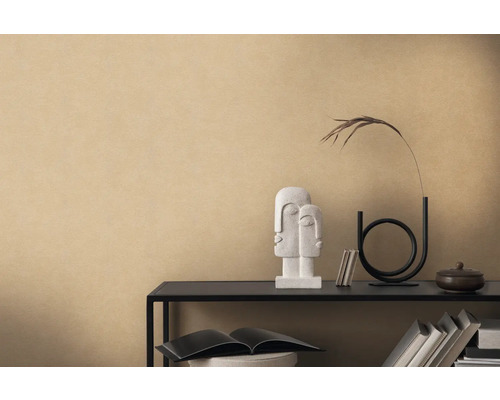 Dekoratives Arrangement mit Skulptur, Vase und Büchern auf einem Regal vor einer beigen Wand