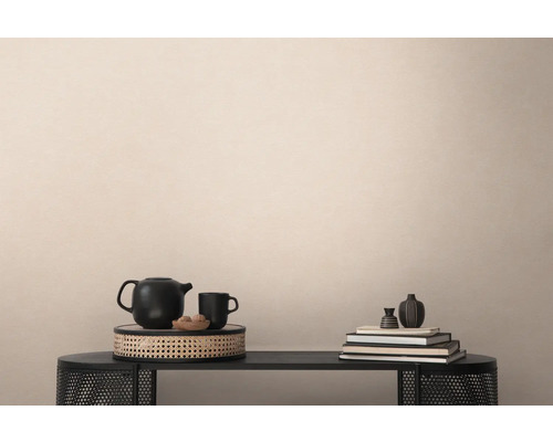 Dekoratives Stillleben auf einem schwarzen Tisch mit Teekanne, Tasse, Büchern und Vasen.