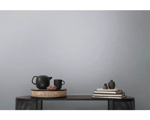 Dekorative Stilllebenanordnung auf einem Tisch mit Teekanne, Tasse, Schale und Büchern.