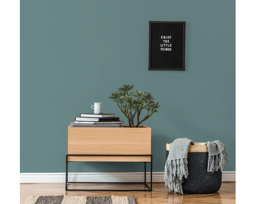 Dekoratives Wohnambiente mit Kommode, Pflanze, Korb und Wandbild