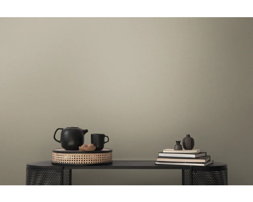 Dekorative Szene mit Teekanne, Tasse, Büchern und Vase auf einem Tisch