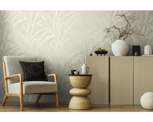 Wohnzimmer mit Sessel, Beistelltisch und Schrank vor einer Wand mit Blattmuster-Tapete