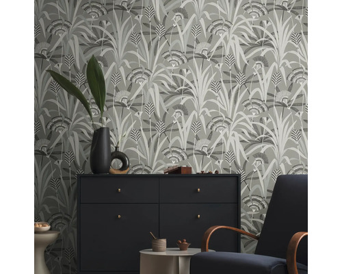 Raumansicht mit floral gemusterter Tapete, Kommode und Sessel