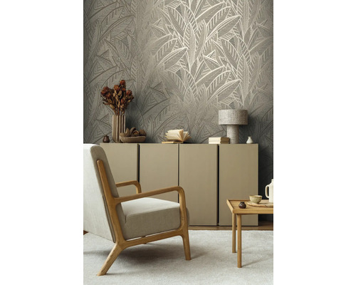 Wohnzimmer mit Blättertapete, Sessel, Kommode und Beistelltisch